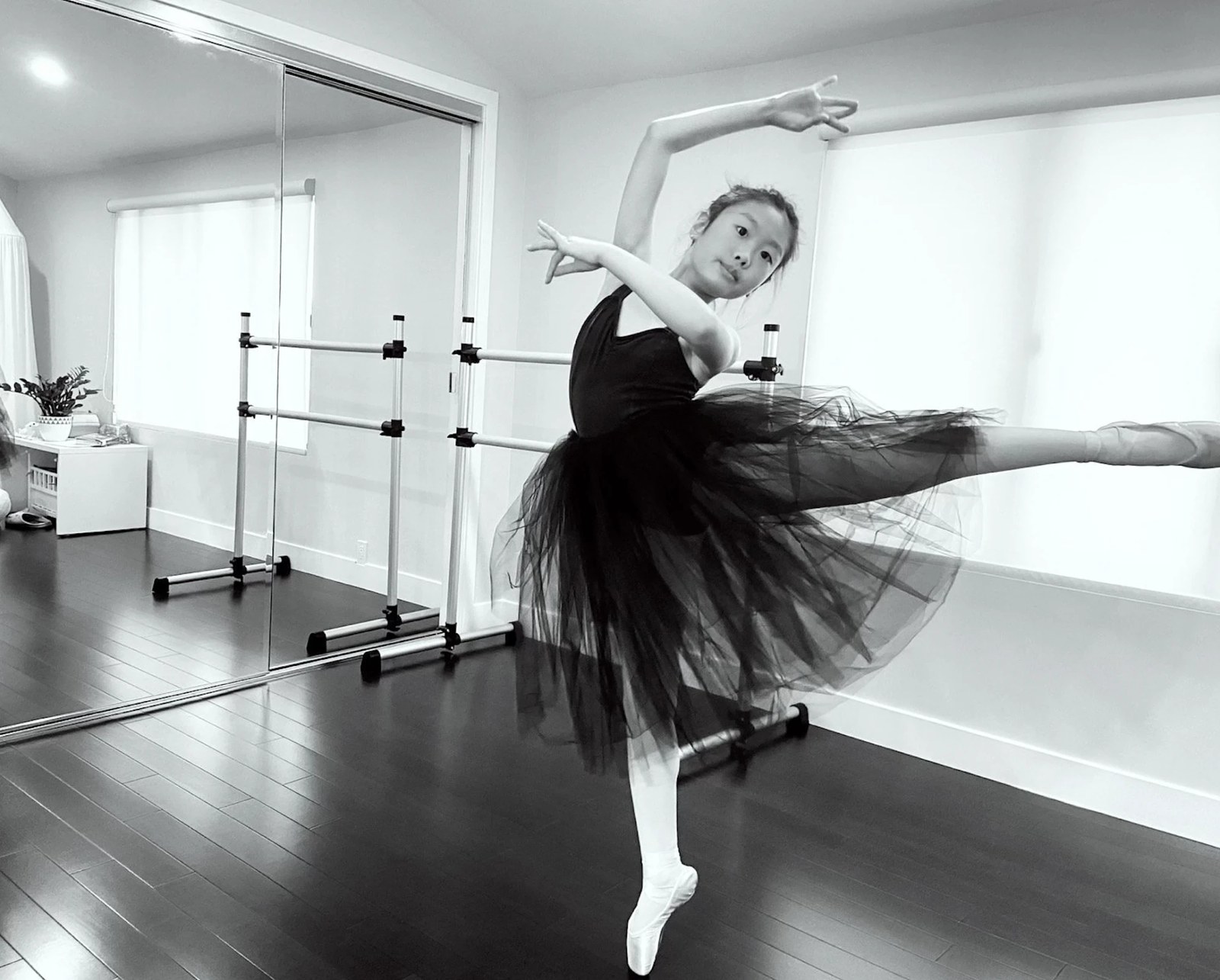 Summer Park in arabesque on pointe in a black tutu