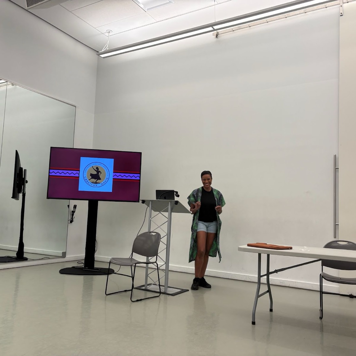 Careitha Davis lecturing beside a slide bearing her name